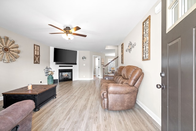 living room featuring ceiling fan, light hardwood / wood-style floors, and a healthy amount of sunlight