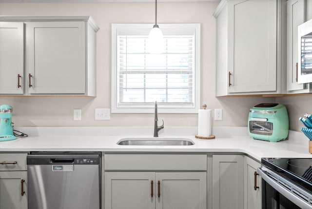 kitchen with hanging light fixtures, sink, range, and stainless steel dishwasher