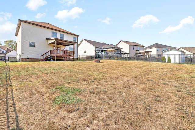 rear view of house with a lawn and a wooden deck