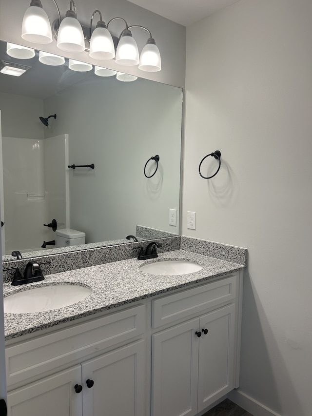 bathroom featuring walk in shower, toilet, and vanity