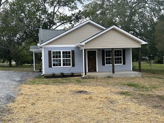 bungalow featuring covered porch and a front lawn