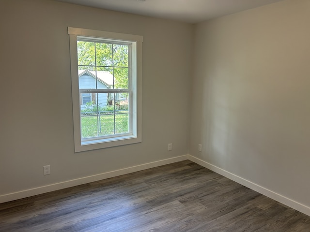 spare room with a healthy amount of sunlight and dark hardwood / wood-style flooring