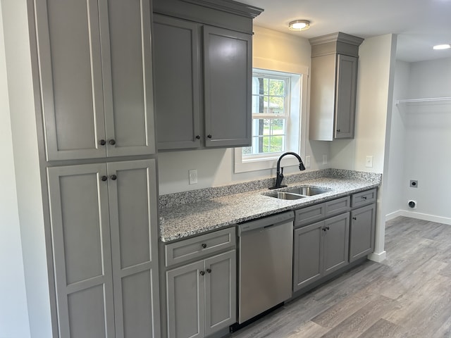 kitchen with gray cabinetry, dishwasher, sink, light stone counters, and light wood-type flooring