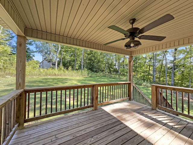 wooden terrace featuring a yard and ceiling fan