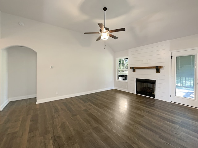 unfurnished living room featuring a large fireplace, ceiling fan, vaulted ceiling, and dark hardwood / wood-style flooring