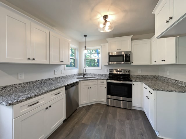 kitchen featuring appliances with stainless steel finishes, sink, white cabinets, and dark wood-type flooring