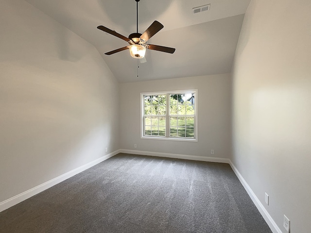 empty room featuring ceiling fan, carpet floors, and vaulted ceiling