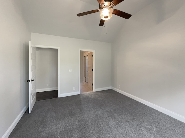 unfurnished bedroom featuring vaulted ceiling, dark carpet, and ceiling fan