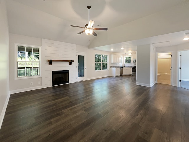 unfurnished living room featuring a fireplace, a wealth of natural light, ceiling fan, and dark hardwood / wood-style floors