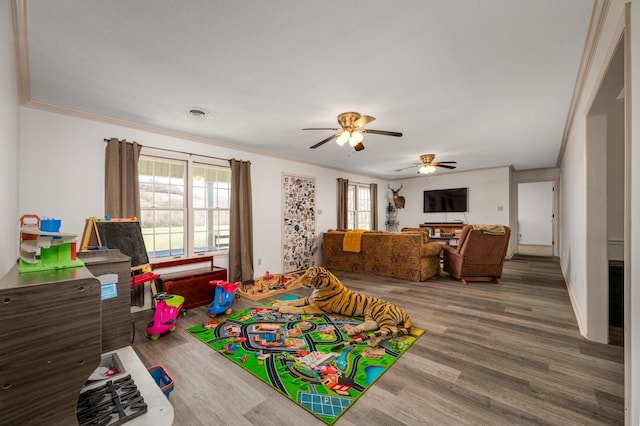 recreation room featuring ceiling fan, hardwood / wood-style flooring, and ornamental molding