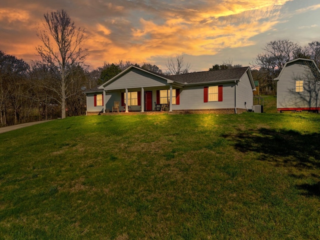 ranch-style house with cooling unit, a lawn, and covered porch