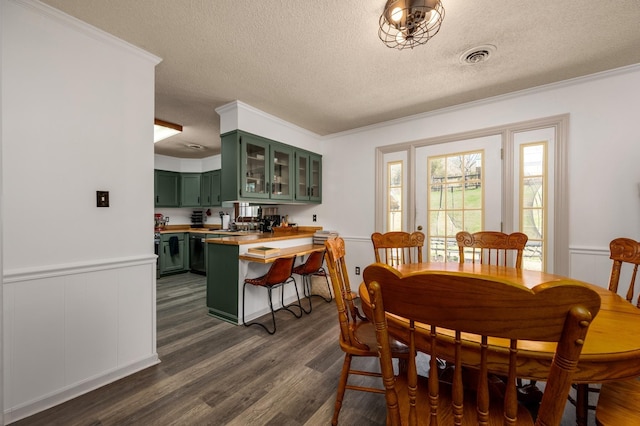 dining room featuring crown molding, dark hardwood / wood-style flooring, and a textured ceiling