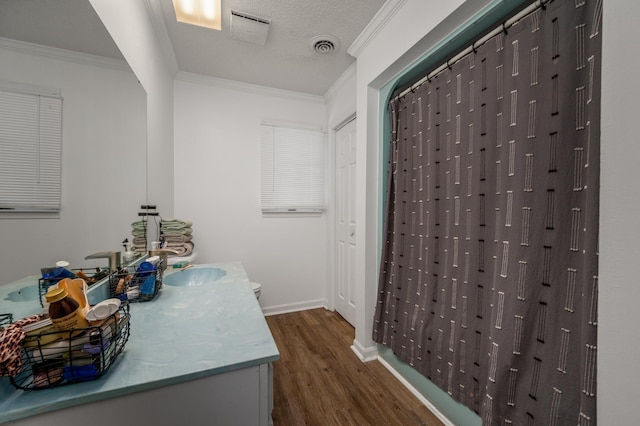 bathroom with hardwood / wood-style flooring, ornamental molding, a textured ceiling, and vanity