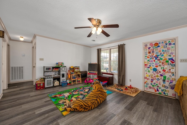 game room featuring ornamental molding, a textured ceiling, hardwood / wood-style floors, and ceiling fan