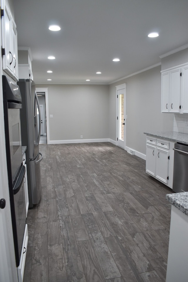 kitchen with crown molding, white cabinetry, light stone counters, and dark hardwood / wood-style floors