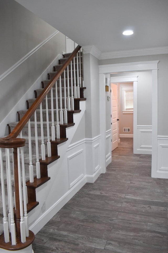 stairway with hardwood / wood-style floors and crown molding