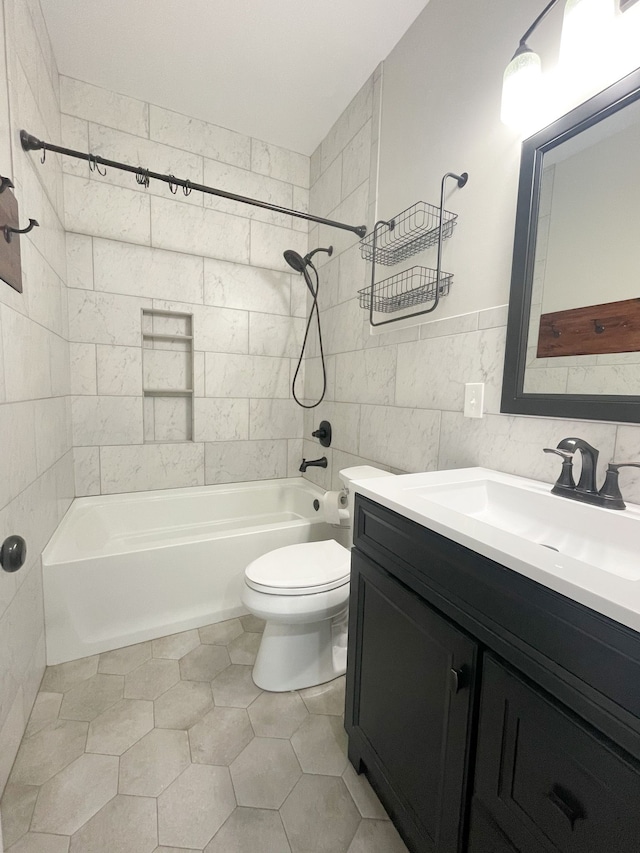 full bathroom with vanity, tile patterned flooring, tile walls, toilet, and tiled shower / bath combo