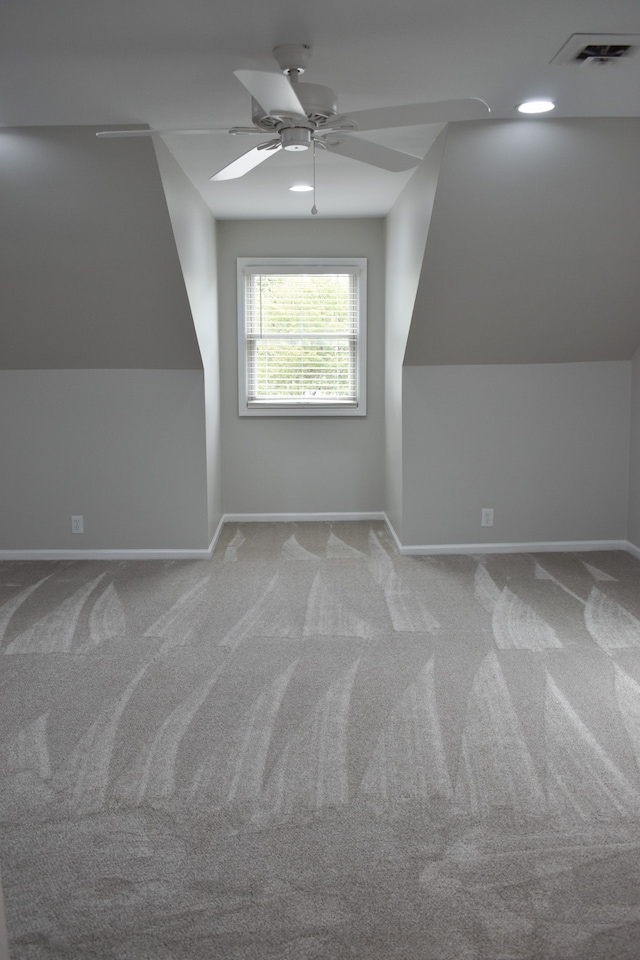 additional living space featuring light colored carpet, vaulted ceiling, and ceiling fan