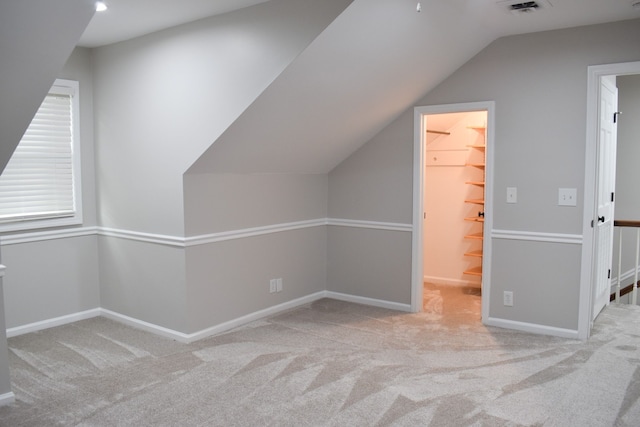 bonus room featuring light colored carpet and vaulted ceiling