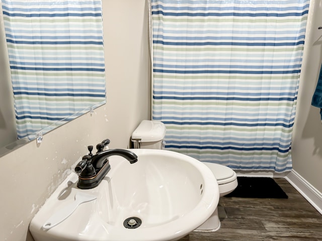 bathroom featuring a shower with curtain, toilet, hardwood / wood-style flooring, and sink