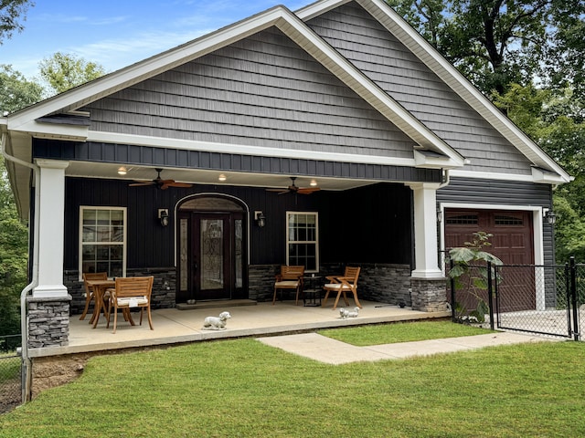 back of property featuring ceiling fan, a lawn, a garage, and a patio