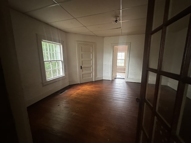 unfurnished room featuring dark hardwood / wood-style floors and a drop ceiling