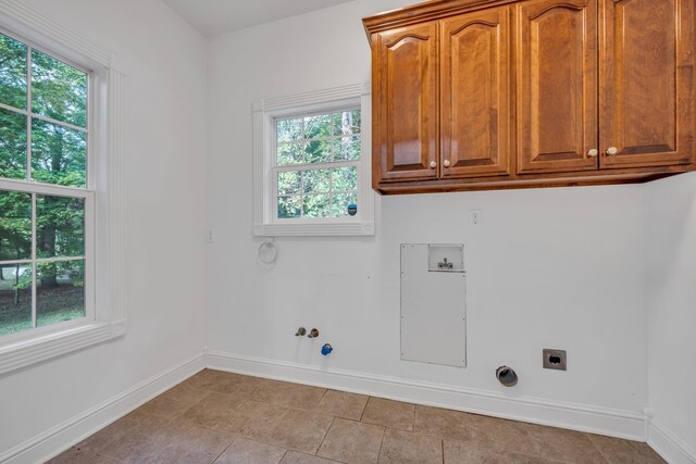 laundry room featuring gas dryer hookup, cabinets, hookup for an electric dryer, and hookup for a washing machine