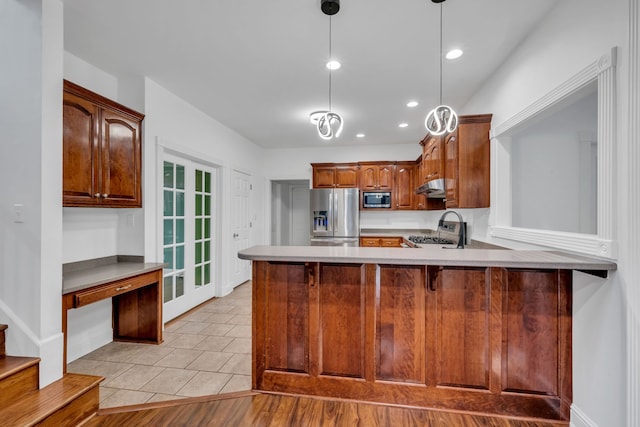 kitchen featuring sink, hanging light fixtures, stainless steel appliances, light tile patterned flooring, and kitchen peninsula