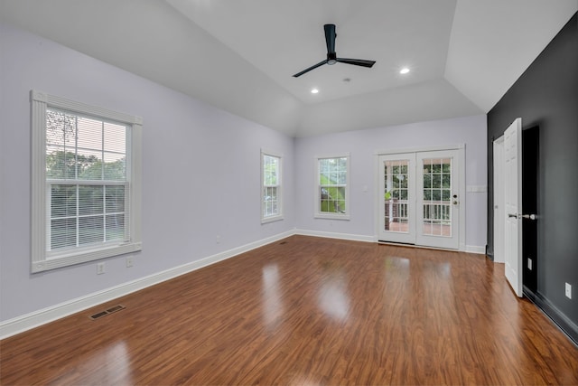 unfurnished room with ceiling fan, a wealth of natural light, vaulted ceiling, and wood-type flooring