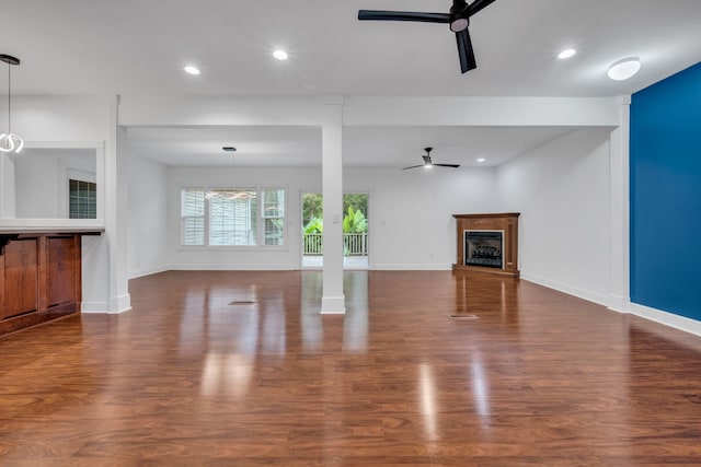 unfurnished living room with dark hardwood / wood-style floors and ceiling fan