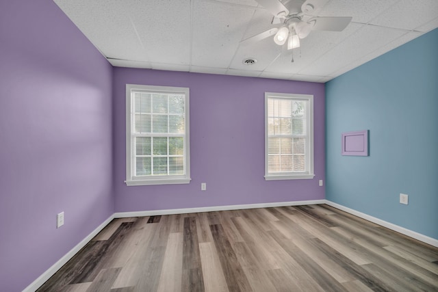 unfurnished room with ceiling fan, a paneled ceiling, and hardwood / wood-style floors