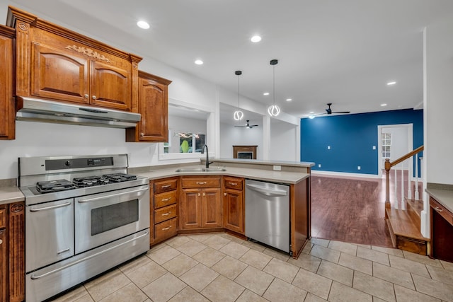 kitchen with sink, hanging light fixtures, appliances with stainless steel finishes, kitchen peninsula, and ceiling fan