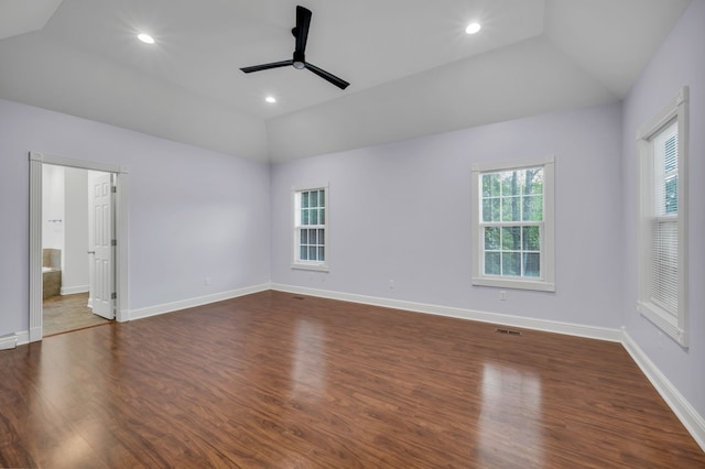 spare room with lofted ceiling, dark wood-type flooring, a wealth of natural light, and ceiling fan