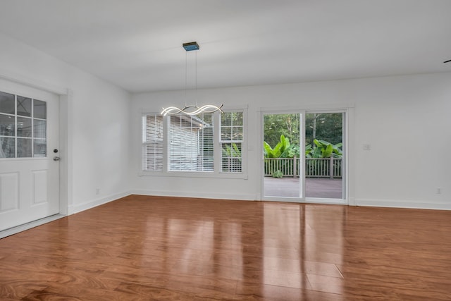 unfurnished dining area with hardwood / wood-style flooring and a chandelier