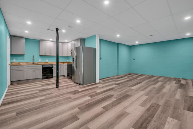 interior space featuring a paneled ceiling, light hardwood / wood-style floors, indoor wet bar, and stainless steel refrigerator with ice dispenser