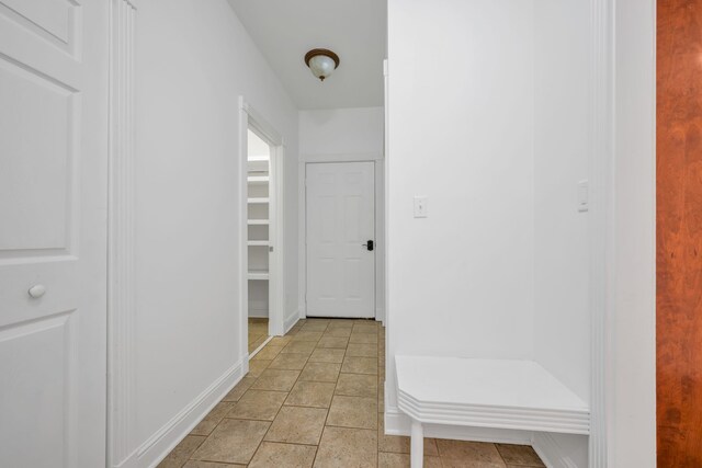 hall with light tile patterned floors