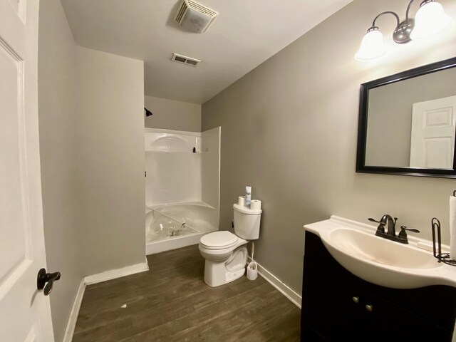 bathroom with vanity, hardwood / wood-style flooring, toilet, and walk in shower