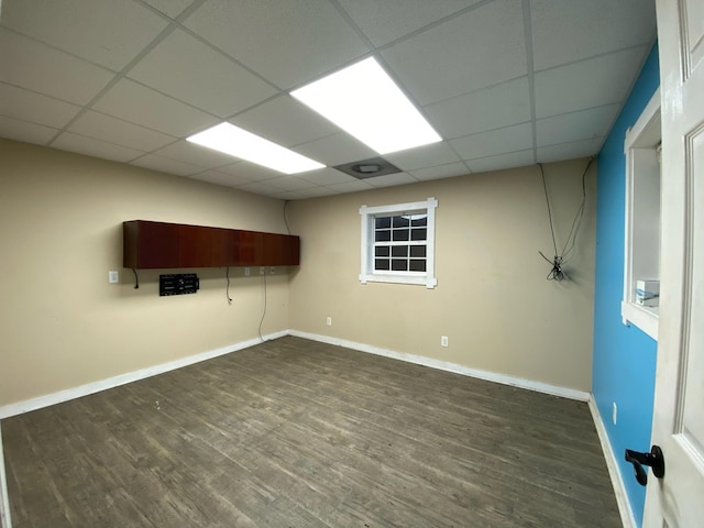 unfurnished room with a drop ceiling and hardwood / wood-style flooring