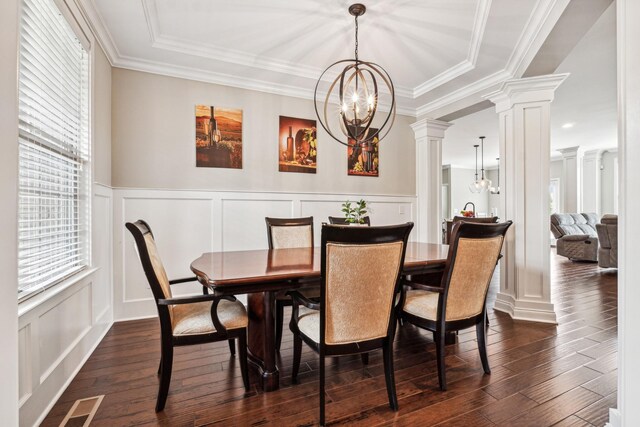 dining room featuring ornamental molding, dark wood-type flooring, an inviting chandelier, and decorative columns