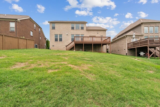 back of house with a wooden deck and a lawn