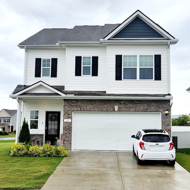 view of front of property with a front yard and a garage