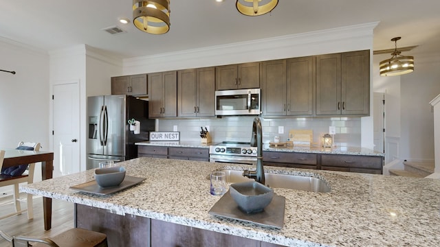 kitchen with light stone counters, tasteful backsplash, stainless steel appliances, crown molding, and sink