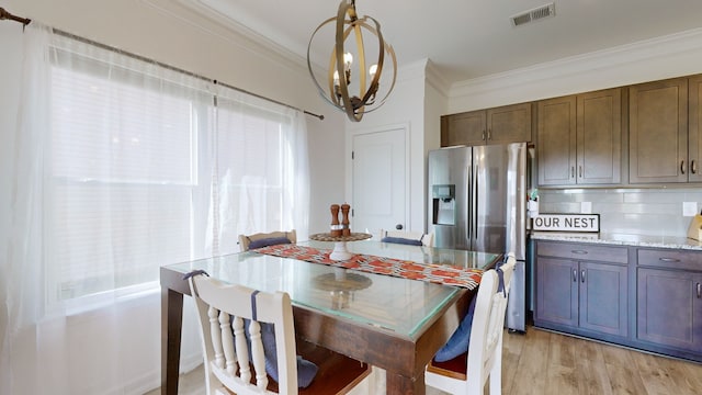 kitchen featuring stainless steel fridge, light hardwood / wood-style floors, crown molding, and tasteful backsplash