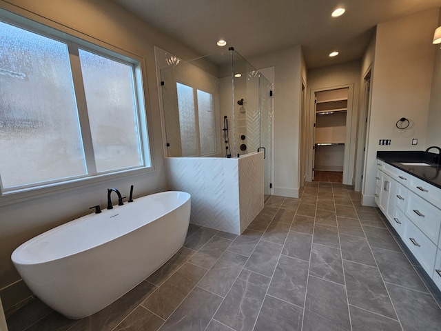 bathroom featuring tile patterned flooring, a wealth of natural light, shower with separate bathtub, and vanity