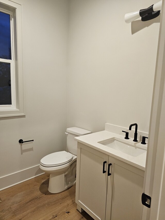 bathroom with vanity, toilet, and hardwood / wood-style flooring