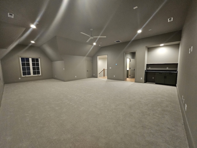 additional living space featuring lofted ceiling and carpet flooring