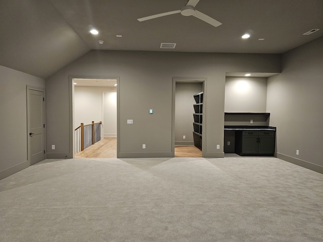 carpeted bedroom featuring lofted ceiling, a walk in closet, and ceiling fan