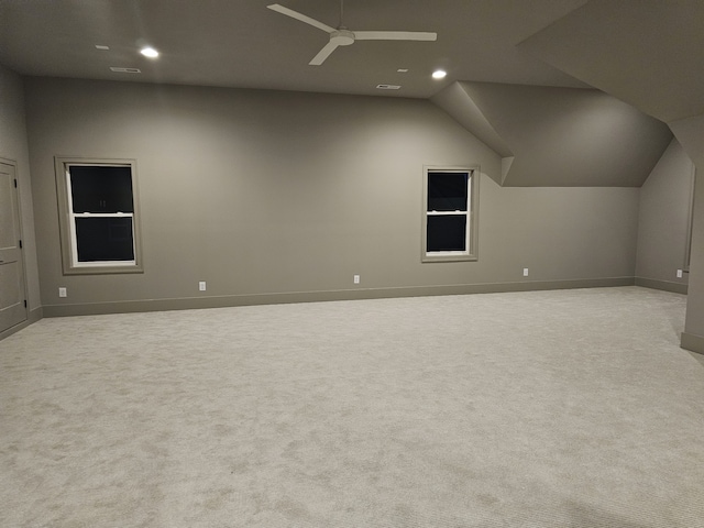 additional living space with ceiling fan, light colored carpet, and vaulted ceiling