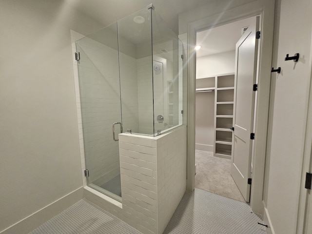 bathroom with a shower with door and tile patterned floors