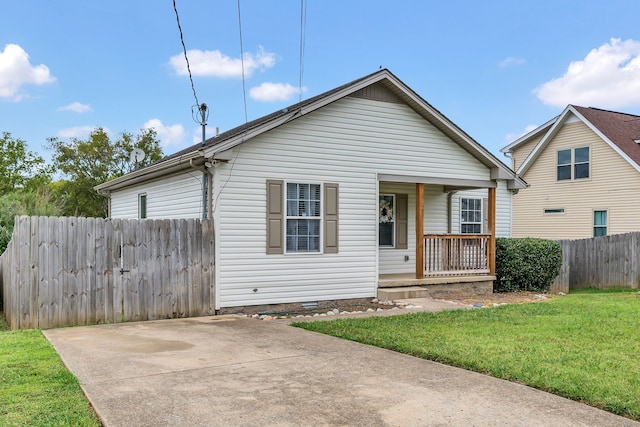 bungalow featuring covered porch and a front yard